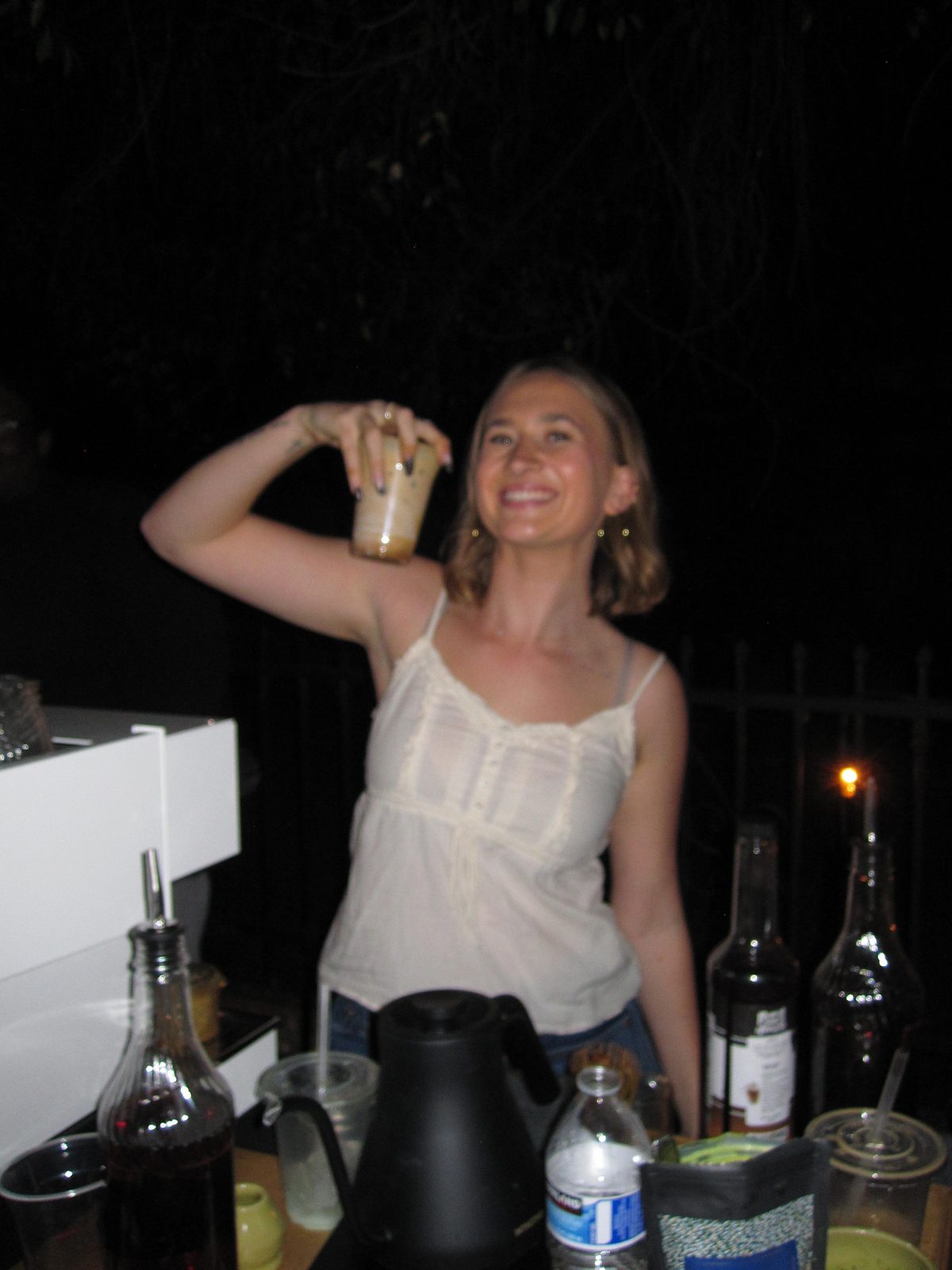 The Garden Coffee Co. barista smiling with a freshly made specialty coffee drink